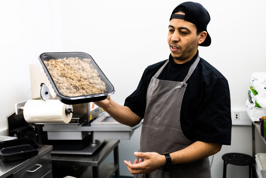 Chef Mounir Nachid holds a package of the Artisan seitan