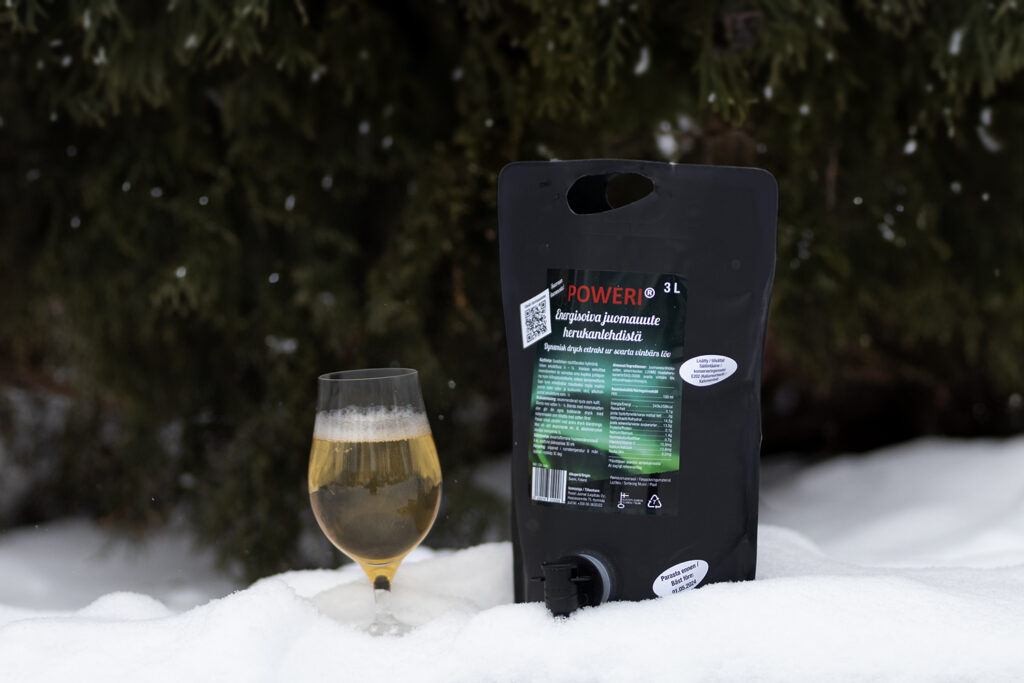 A pouch of drink extract beverage crafted from Finnish blackcurrant leaves, picture in a snowy landscape