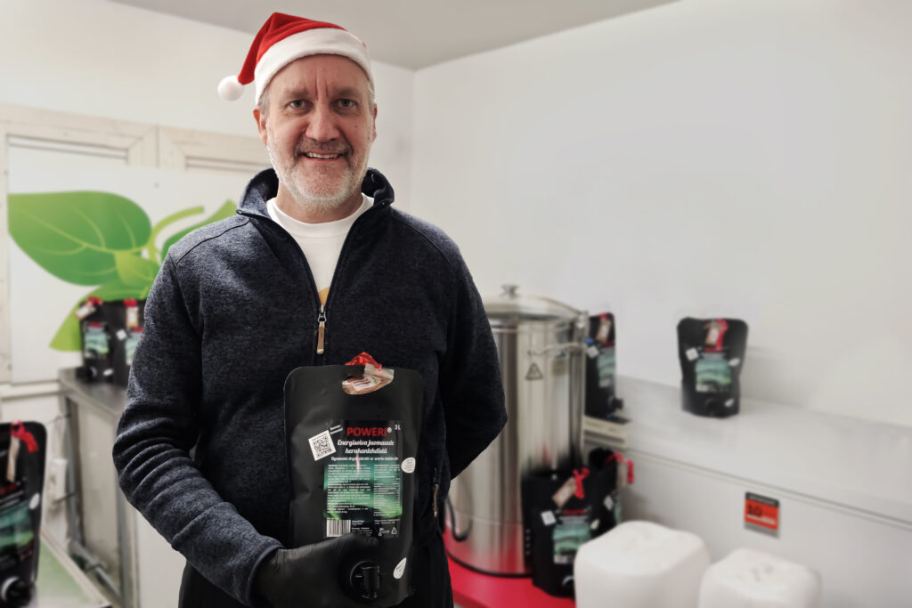 Jyrki Raikamo, donned in a Santa hat, offering tastings of a new creation – a drink extract beverage crafted from Finnish blackcurrant leaves.